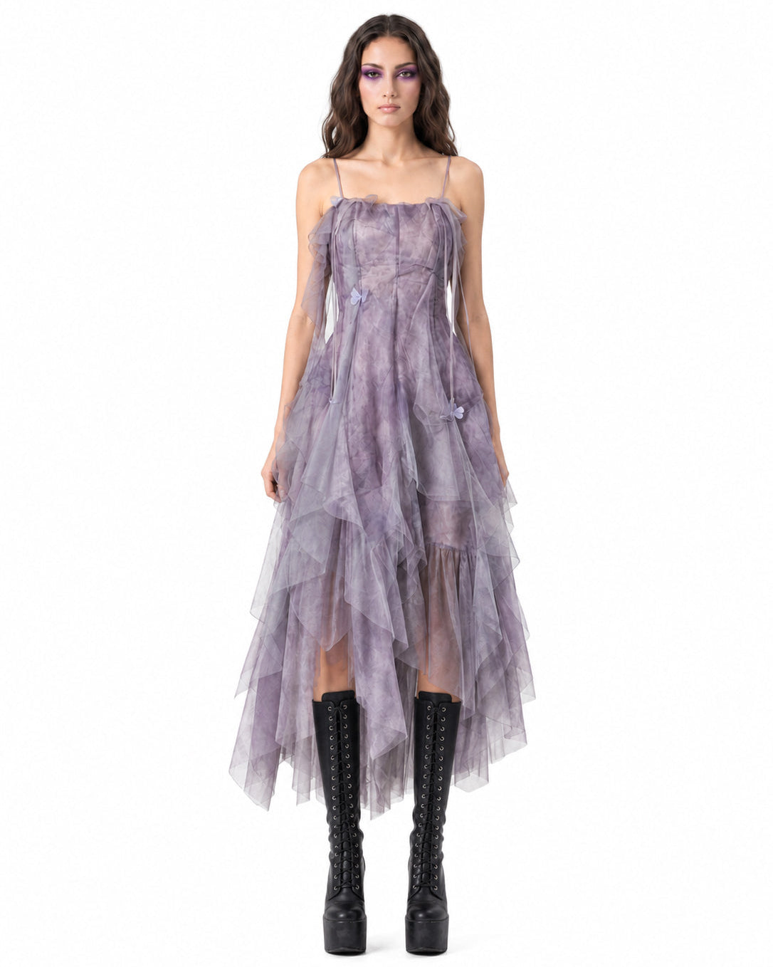 Woman wearing a purple dress with sheer panels on a white background