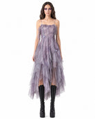 Woman wearing a purple dress with sheer panels on a white background